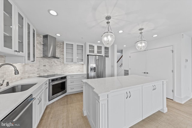 kitchen featuring sink, stainless steel appliances, white cabinetry, and a center island