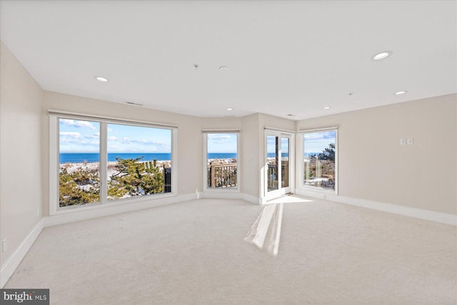 carpeted spare room with a water view