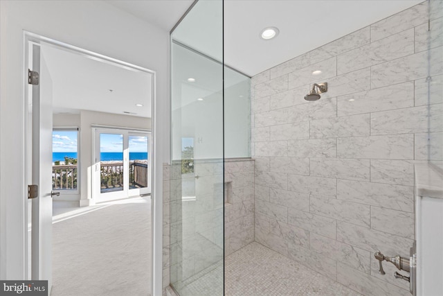 bathroom featuring tiled shower and a water view