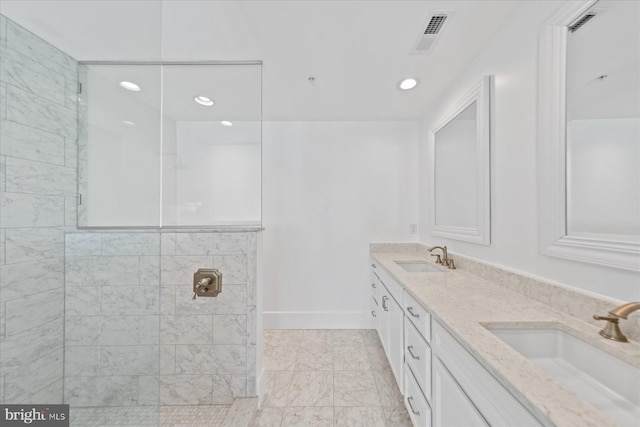 bathroom with a tile shower and vanity