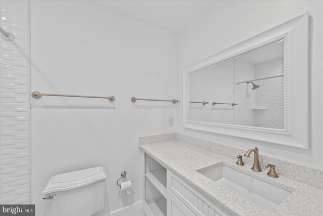 bathroom featuring a shower, vanity, and toilet