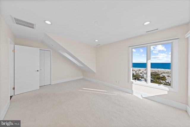 bonus room with a beach view, light carpet, and a water view