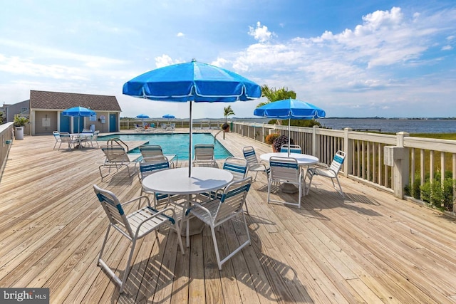 wooden deck featuring a community pool and a water view