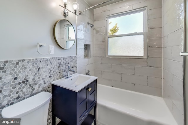 full bathroom featuring tile walls, toilet, vanity, and tiled shower / bath