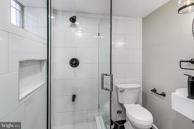 bathroom featuring toilet and an enclosed shower