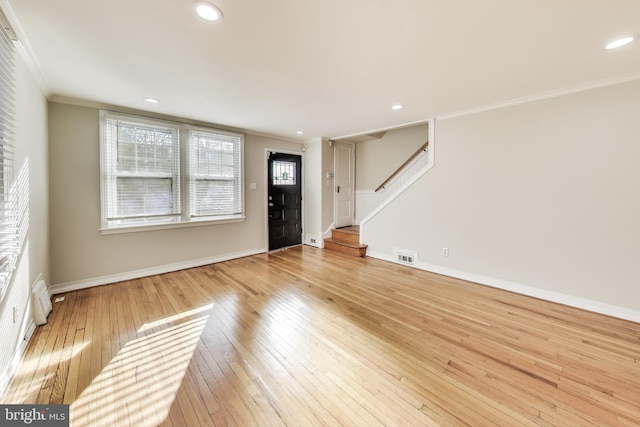 foyer with light hardwood / wood-style floors and ornamental molding