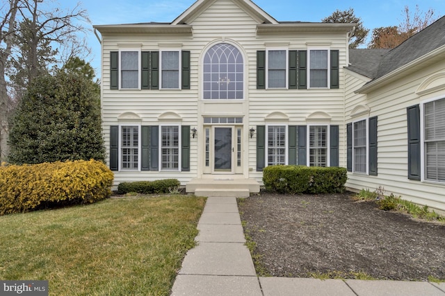 colonial-style house with a front lawn