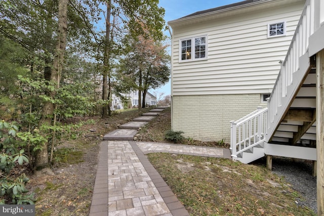 view of home's exterior featuring stairway and brick siding