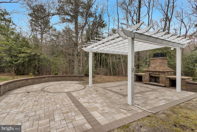 view of patio with an outdoor stone fireplace and a pergola