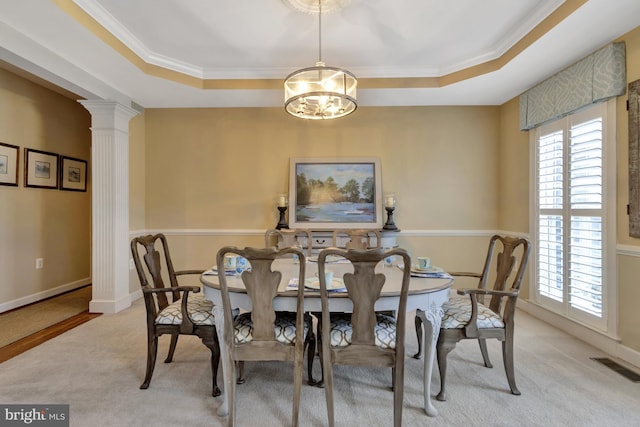 carpeted dining room featuring ornate columns, visible vents, a raised ceiling, and an inviting chandelier