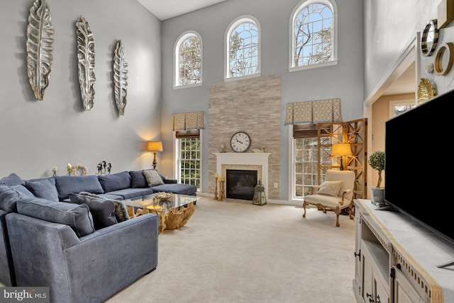 living room with a fireplace with flush hearth, a healthy amount of sunlight, and light carpet