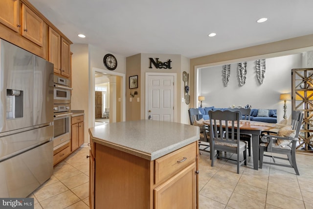 kitchen featuring light tile patterned floors, recessed lighting, stainless steel refrigerator with ice dispenser, open floor plan, and a center island