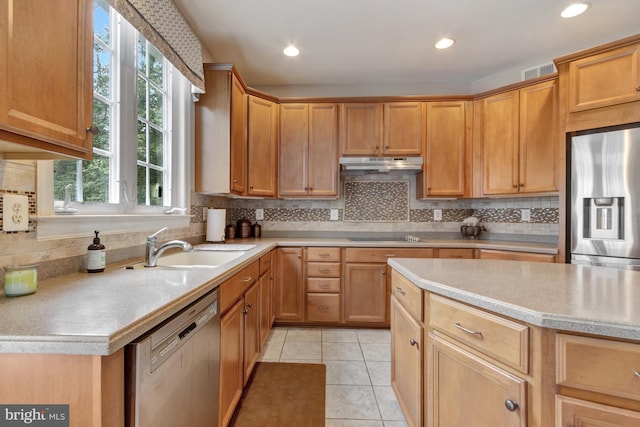 kitchen featuring under cabinet range hood, a sink, stainless steel appliances, light countertops, and light tile patterned floors