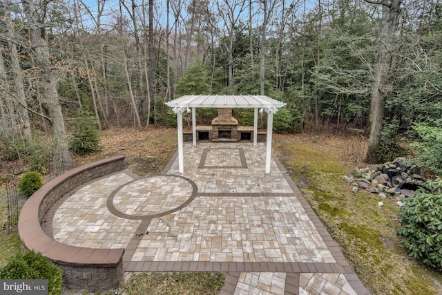 view of patio / terrace with an outdoor stone fireplace and a pergola