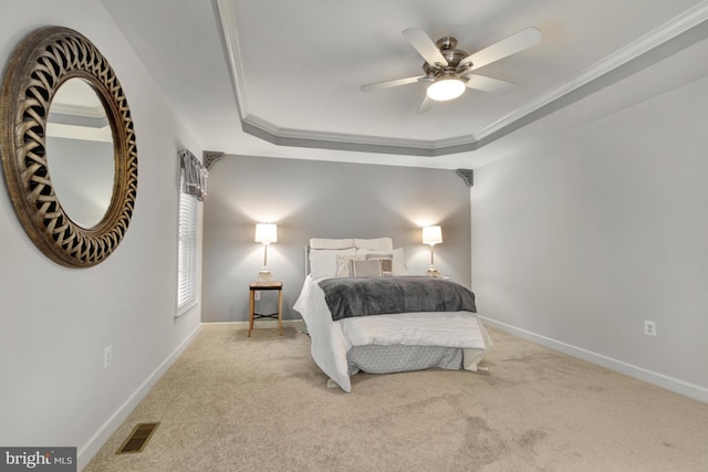 carpeted bedroom featuring visible vents, a raised ceiling, baseboards, and crown molding