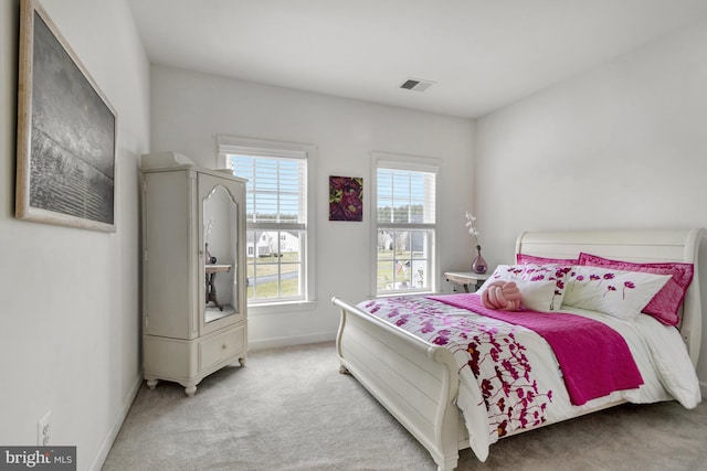 carpeted bedroom featuring visible vents and baseboards