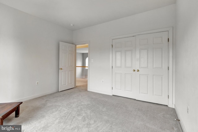 unfurnished bedroom featuring a closet, baseboards, and carpet