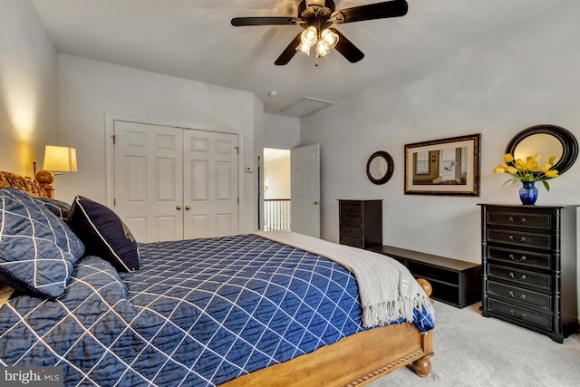 carpeted bedroom featuring a closet, attic access, and ceiling fan