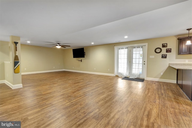 unfurnished living room featuring recessed lighting, a ceiling fan, light wood-type flooring, and baseboards