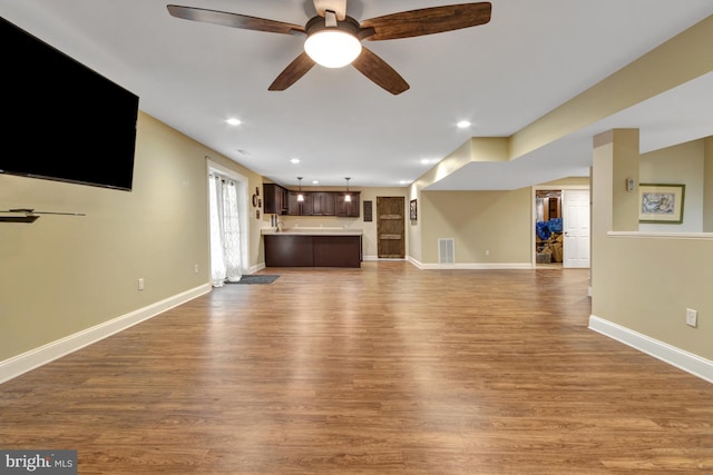 unfurnished living room with recessed lighting, wood finished floors, visible vents, and baseboards