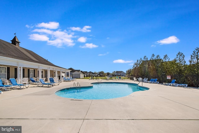 pool with fence and a patio area