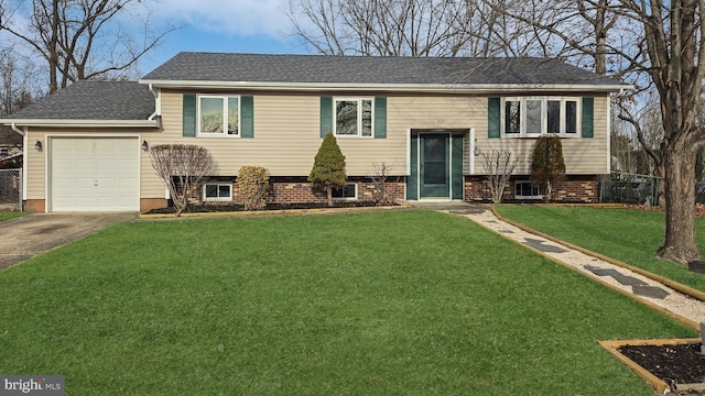 raised ranch featuring a front lawn and a garage