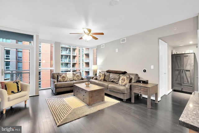 living room featuring ceiling fan and dark hardwood / wood-style flooring