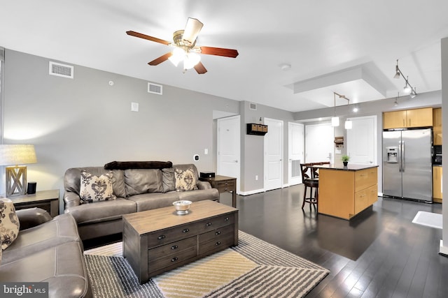 living room with rail lighting, ceiling fan, and dark wood-type flooring