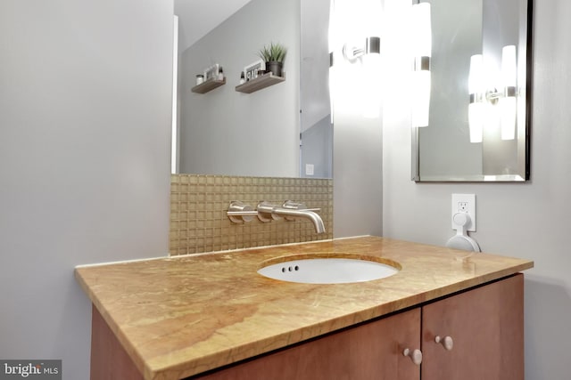 bathroom featuring vanity and backsplash