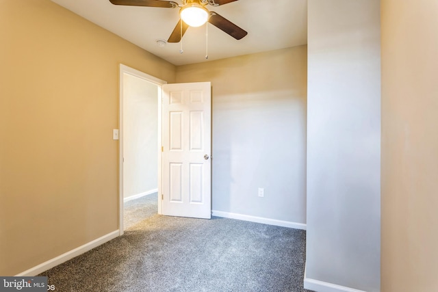 empty room with ceiling fan and dark colored carpet