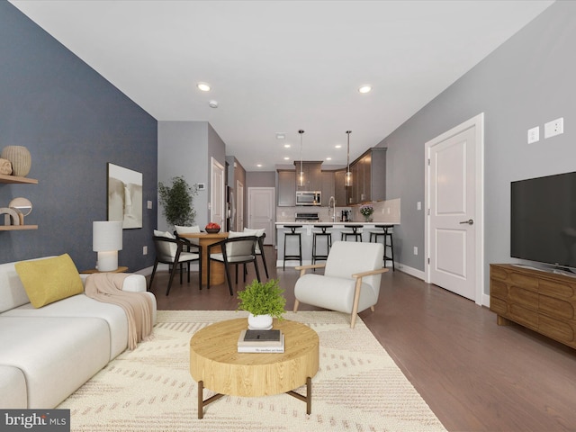 living room featuring dark wood-type flooring and sink