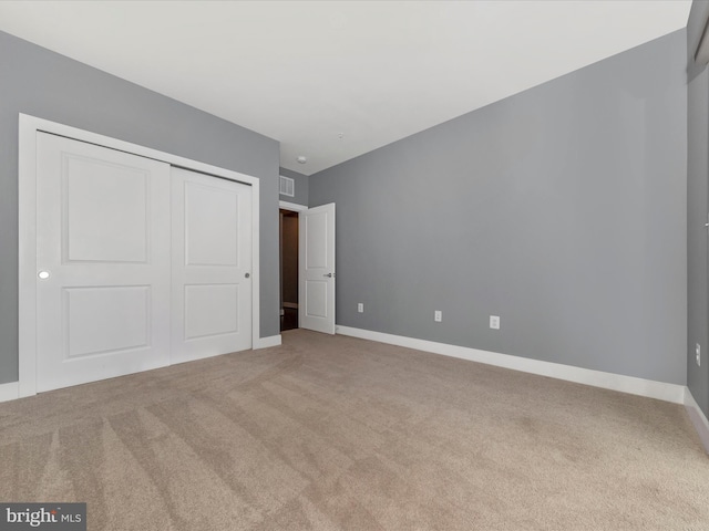 unfurnished bedroom with carpet floors and a closet