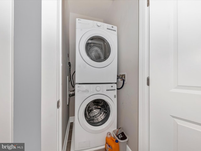 clothes washing area with stacked washing maching and dryer