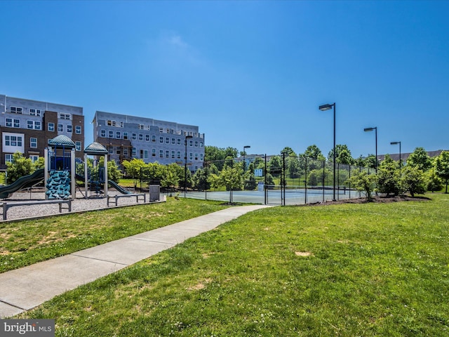 view of community featuring a yard, tennis court, and a playground