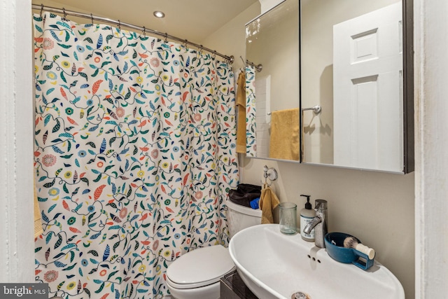 bathroom with toilet, a shower with curtain, and sink