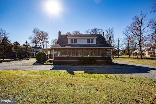 rear view of house with a sunroom and a yard