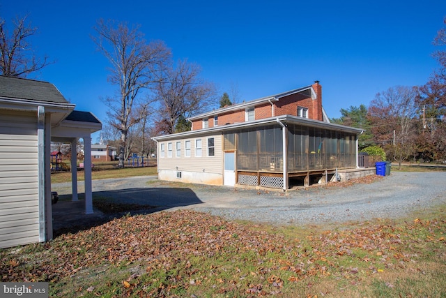 view of property exterior featuring a sunroom