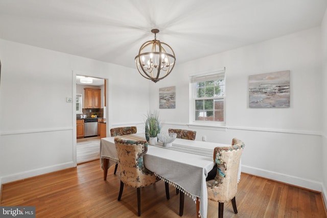 dining area with a notable chandelier and light hardwood / wood-style floors