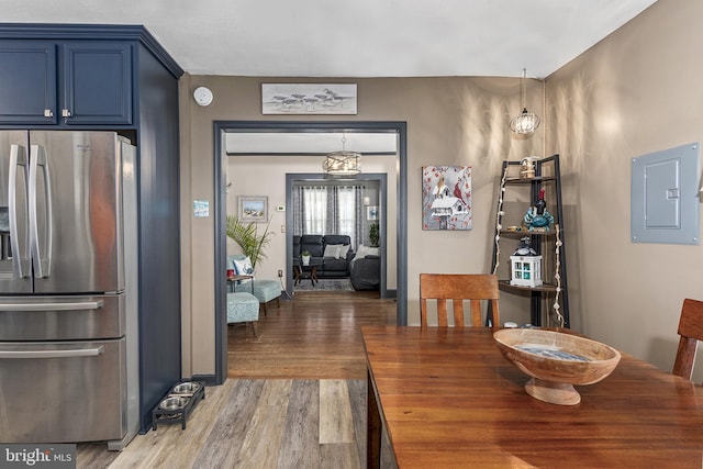 dining space with wood finished floors and electric panel