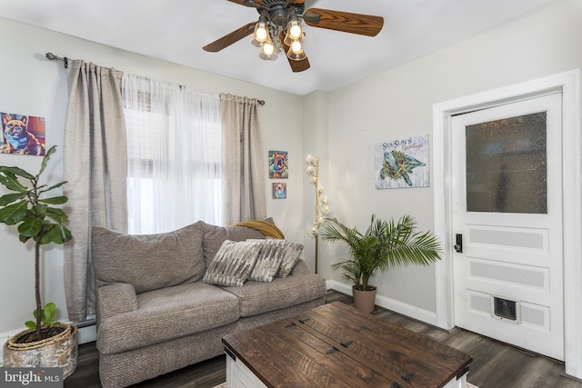 living area with dark wood-style floors, a baseboard radiator, baseboards, and a ceiling fan