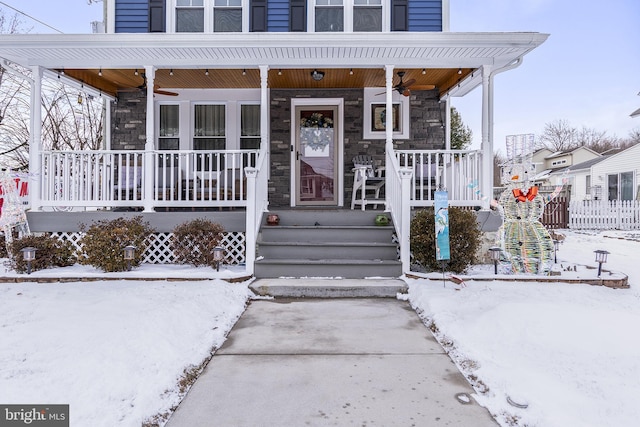 snow covered property entrance featuring a porch