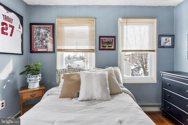 bedroom with dark wood-type flooring, multiple windows, and a textured ceiling