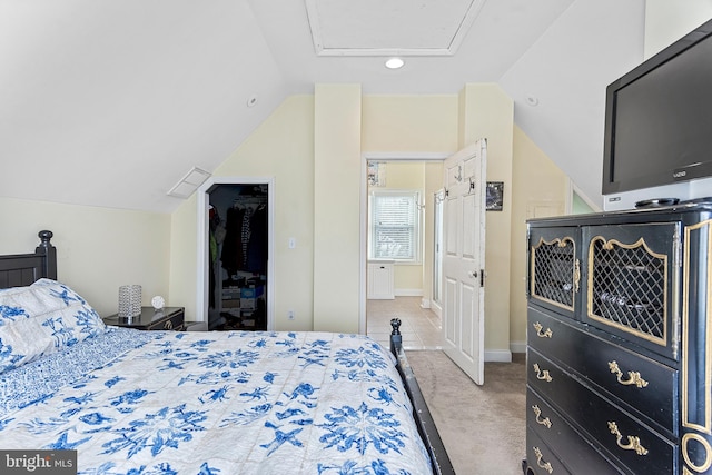 bedroom featuring lofted ceiling, a closet, a spacious closet, light carpet, and baseboards