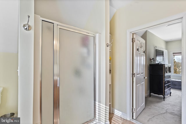 full bath featuring a stall shower and baseboards