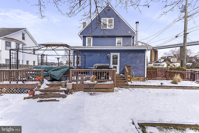 snow covered rear of property featuring a gazebo, a wooden deck, and fence