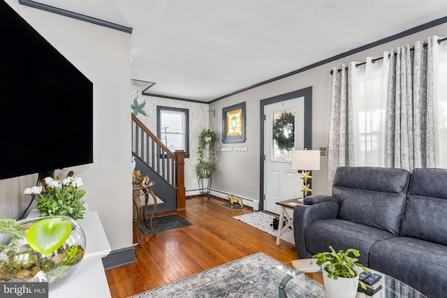 living area featuring a baseboard radiator, stairway, ornamental molding, wood finished floors, and baseboards