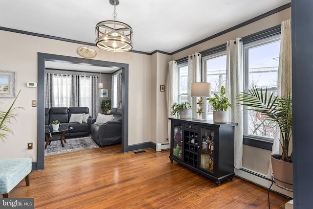 interior space featuring a chandelier, ornamental molding, dark wood-style flooring, and baseboard heating