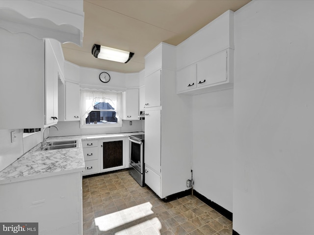 kitchen featuring electric stove, sink, and white cabinets