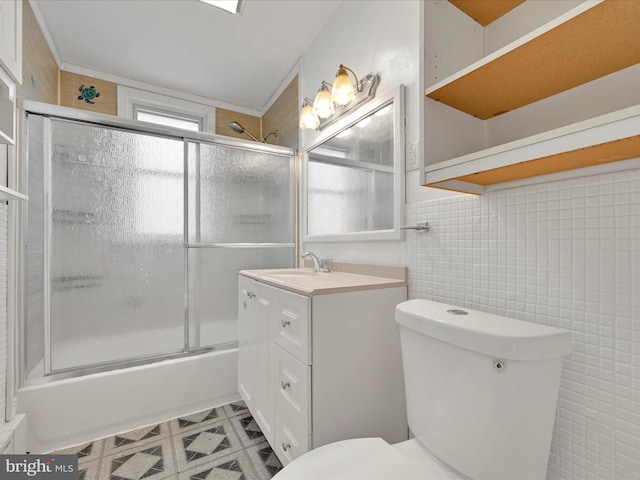 full bathroom featuring tile walls, vanity, enclosed tub / shower combo, and toilet