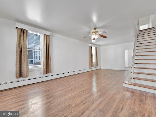 unfurnished living room featuring hardwood / wood-style flooring, ceiling fan, and a baseboard heating unit